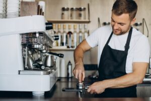 Barista pressing espresso ground before brewing