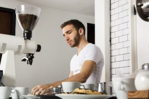 Man in front of coffee bean grinder preparing ingredients